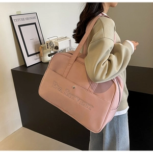 Rosa Reisetasche mit großer Kapazität und Stickerei in Lifestyle-Szene dargestellt