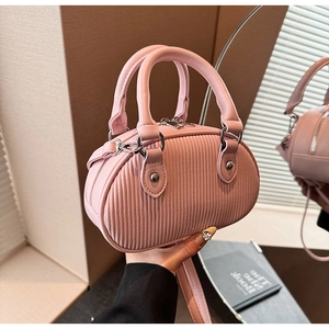 Dettaglio della mini borsa rosa con trama plissettata verticale e fibbie in metallo argento