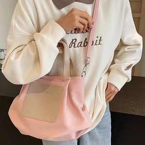 Sac cabas en nylon rose avec poche beige et bandoulière porté avec tenue décontractée