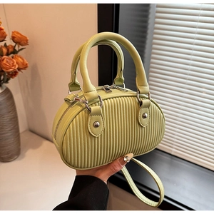 Dettaglio mini borsa verde pistacchio con trama a pieghe verticali e finiture argentate