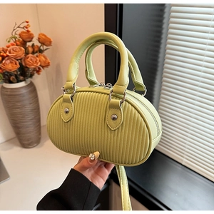 Dettaglio borsa a tracolla verde avocado plissettata con doppi manici e zip in metallo