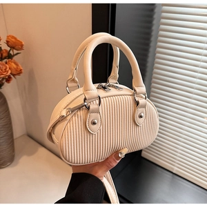 Dettaglio mini borsa a tracolla crema con pieghe verticali e hardware in metallo argento