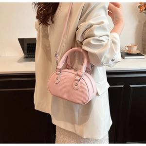 Vista dettagliata della mini borsa a tracolla rosa plissettata indossata da modella