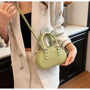 Dettaglio della mini borsa verde avocado a pieghe con catena argento e manico