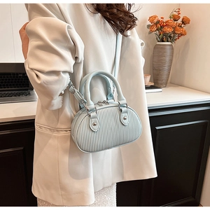 Dettaglio della mini borsa azzurra a pieghe con texture rifinita e tracolla a catena