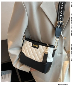 Detail of contrast bucket bag with quilted white leather and geometric woven strap