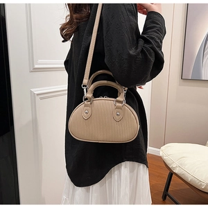 Mini borsa chic in pelle arricciata beige con dettagli argento mostrata su modella