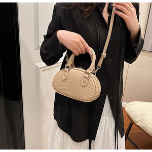 Dettaglio della borsa a mano beige a pieghe con finiture argentate e finitura in pelle