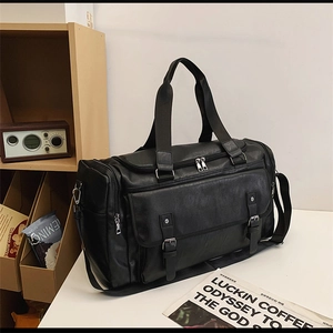 Detail of black vintage travel bag featuring faux leather buckles and an adjustable strap