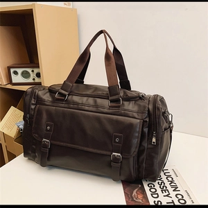Close-up of a large capacity dark brown PU leather travel bag on a wooden desk
