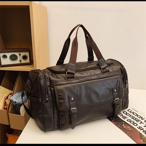 Detail of a dark brown faux leather travel bag with vintage buckle straps and handles