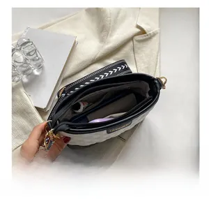 Detail view showing organized multi-compartment interior of a quilted contrast crossbody bag