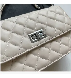 Detailaufnahme einer beigefarbenen Stepptasche aus Leder mit silbernem Drehverschluss