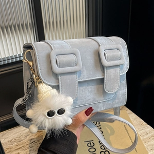 Minimalist light blue crossbody bag with vintage stone texture and plush monster charm