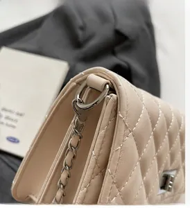 Nahaufnahme der beigen gesteppten Ledertasche mit silberner Kette und Drehverschluss