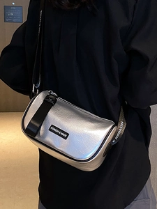 Metallic silver crossbody bag with pleated texture and adjustable logo strap on model