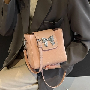 Pink leather bucket bag with silver bow accent and adjustable shoulder strap for women