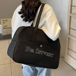 Große schwarze Reisetasche aus Segeltuch mit modischer weißer Buchstabenstickerei