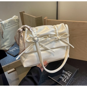 Detail of cream white pleated tote bag with bows and heart print silk scarf handle