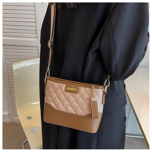 Detail of contrast stitch bucket bag with quilted beige top and brown leather base