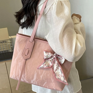 Pink crinkle texture tote bag with silk scarf bow shown on model in a stylish scene