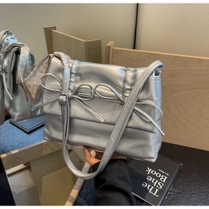 Silver metallic tote bag detail with decorative bow and heart pattern silk scarf handle