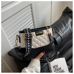 Detail of quilted diamond pattern on black and white leather bag with wide strap