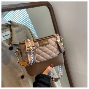 Detail of quilted brown crossbody bag with jacquard strap and gold metallic hardware
