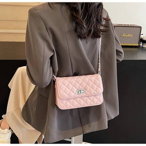 Detail der rosa gesteppten Mini-Tasche aus Leder mit silberner Kette an einem Model