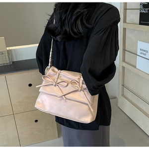 Detail of soft pink tote bag with double bow decoration and pleated design on shoulder
