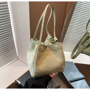 Dettaglio della borsa a secchiello verde chiaro con texture marmorizzata e tracolla lunga