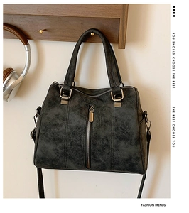 Detail of dark grey vintage tote bag with soft leather texture and silver zipper accents
