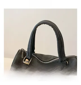 Detail of thickened handle and metal hardware on dark grey suede leather tote bag