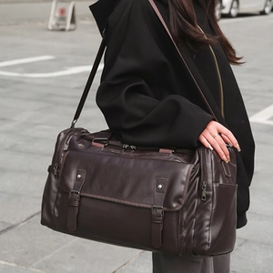 Large dark brown travel duffel bag in pebble leather with adjustable shoulder strap