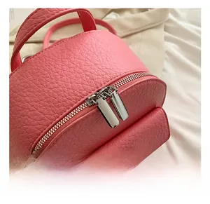Macro detail of high-quality silver double zippers on pink lychee grain leather bag