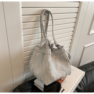 Dettaglio della borsa a spalla plissettata grigio chiaro in materiale materico moderno