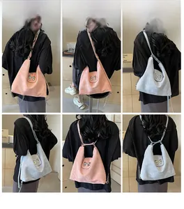 Détail de la texture en cuir brillant et du fermoir nœud métallique sur le sac