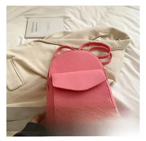 Close-up of pink pebble grain leather backpack with drawstring and front flap pocket detail