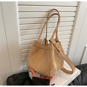 Dettaglio della borsa a secchiello kaki con trama plissettata vintage e tracolle regolabili