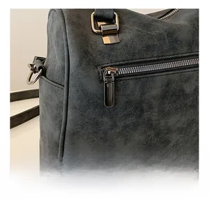 Detail of smooth gunmetal zipper and textured synthetic leather on retro tote bag