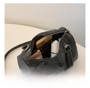 Macro view of the spacious inner compartments of this grey suede Boston tote bag