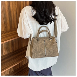 Detailed view of the large khaki Boston tote bag showing vintage leather texture and handles