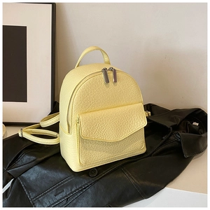 Detailed close-up of light yellow pebble leather mini backpack with silver hardware