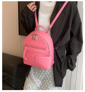 Close-up of a pink mini backpack for women in pebbled faux leather with silver zippers