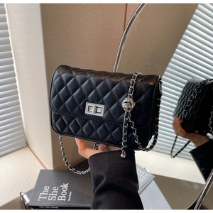 Detailansicht der schwarzen Stepptasche mit silbernem Drehverschluss und Kettenriemen