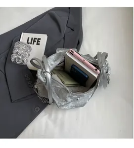 Vue intérieure montrant la grande capacité d'un sac cabas argenté avec objets du quotidien