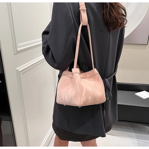 Borsa a secchiello rosa effetto marmo indossata da modella con blazer nero vista laterale