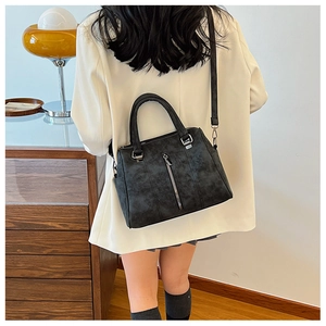 Model wearing a black vintage tote bag with retro texture and adjustable shoulder strap