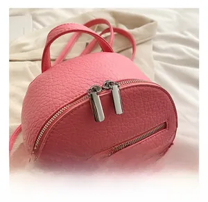 Detail of pink mini backpack featuring fine litchi grain texture and silver zippers