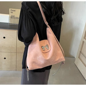 Détail du sac cabas rose avec ornement nœud argenté et franges de chaînes métalliques